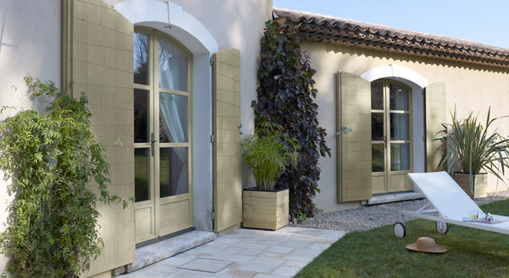 Façade maison avec grandes portes fenêtres sur jardin avec transat
