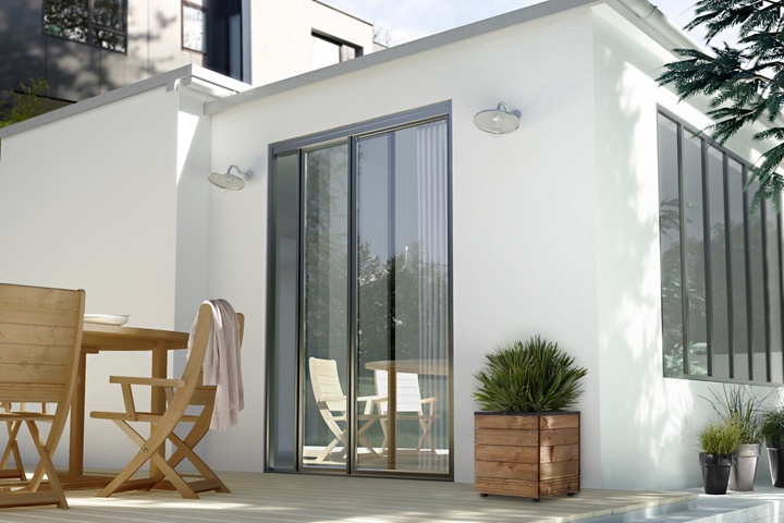 Façade maison blanche avec baie-vitrée et salon de jardin bois