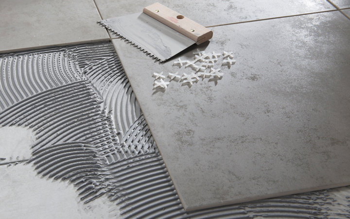 Carrelage gris en train d'être posé avec platoire colle et croisillons