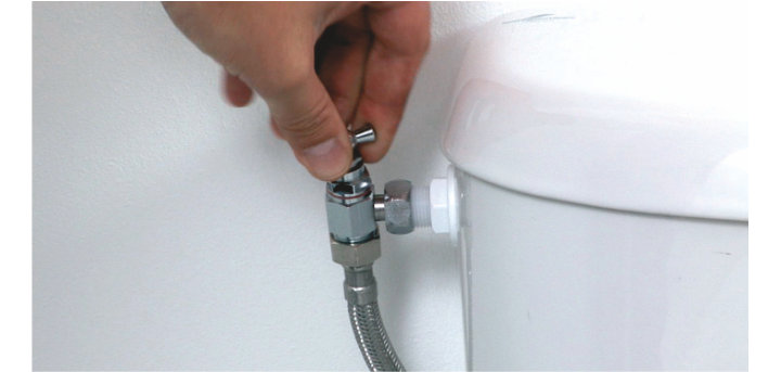 Personne qui tourne robinet d'eau des toilettes