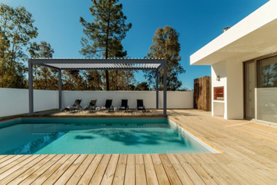 Une belle piscine enterrée avec une terrasse devant une maison