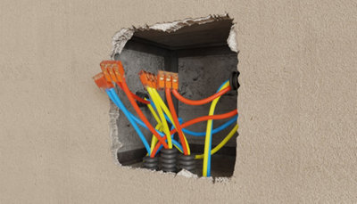 Trou dans mur avec câbles qui en sortent