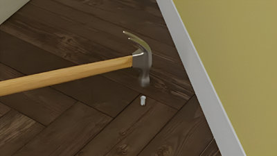 Cheville enfoncée dans parquet avec marteau