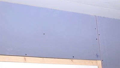 Plaque de plâtre fixé en haut de la porte