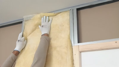 Installation de l'isolant sur la plaque dans l'ossature