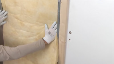 Installation de l'isolant sur la plaque dans l'ossature