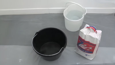 seau vide, seau d'eau et sac de mortier adhésif