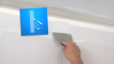 Application enduit mur avec spatule et schéma montrant angle de 45°