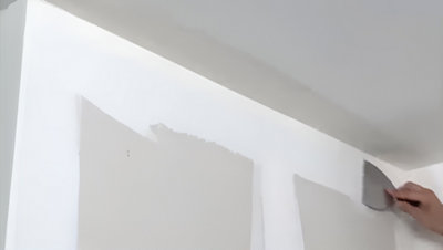 Personne qui gratte les excédent du mur