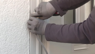 personne posant joint étanchéité sur porte