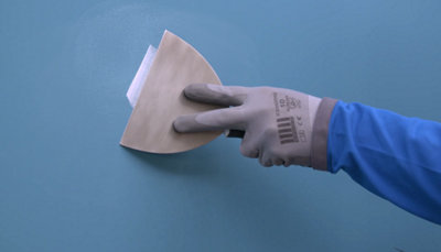 application enduit sur mur avec spatule
