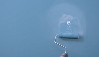passage du rouleau de peinture bleu sur mur