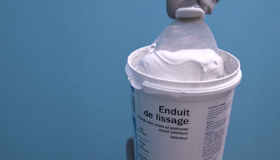 spatule dans pot d'enduit de lissage