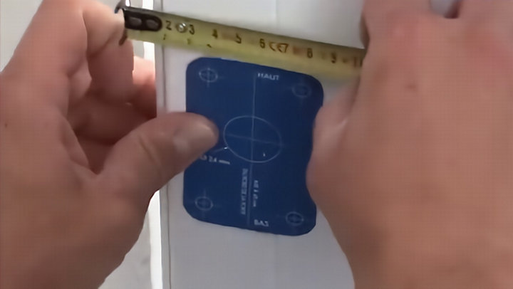 Mesure de la distance du gabarit avec un mètre sur la porte