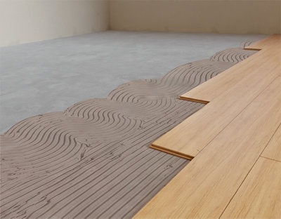 Parquet massif en cours d'installation avec de la colle sur le sol