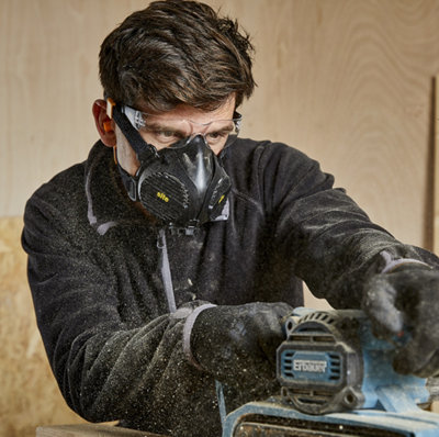 personne découpe bois avec masque filtre
