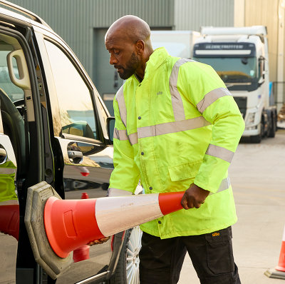 Personne avce veste haute visibilité jaune range plot dans camionnette
