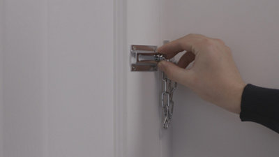 Personne mettant l'entrebâilleur de porte