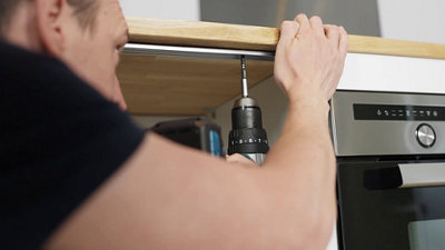 Fixez les plans de travail en insérant les vis par le dessous du meuble bas via les trous dans les rails métallique à l’avant et à l’arrière.​