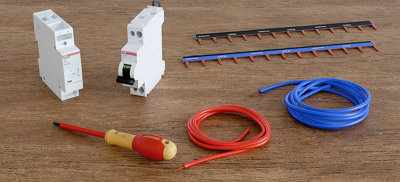 Un contacteur jour/nuit, un tournevis d'électricien et du fil sur une table