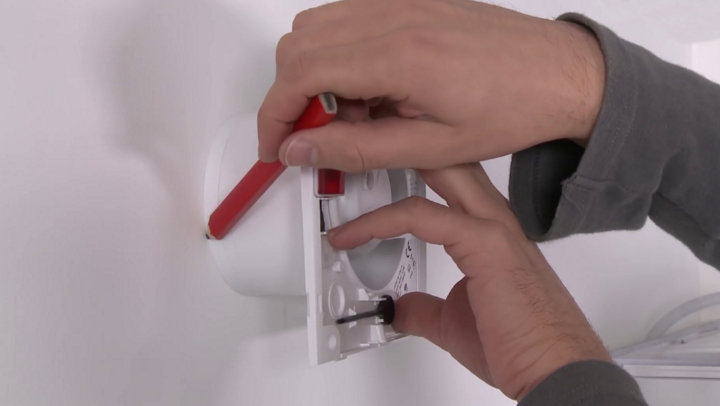 Traçage repère extracteur sur le mur avec crayon