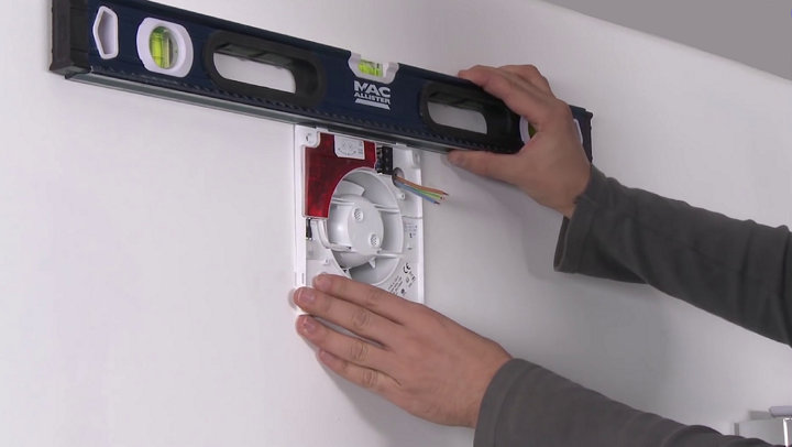 Contrôle avec niveau à bulle positionnement extracteur au mur