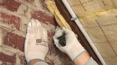 découper de fines bandes de laine et glissez-les entre le mur et les chevrons à l'aide du couteau à enduire