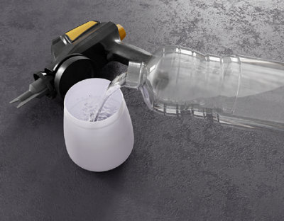 personne versant de l'eau dans le réservoire du pistolet