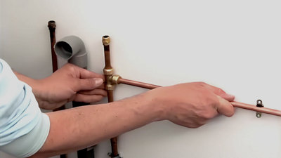 Insérez maintenant le tuyau en cuivre à l’intérieur du T et fixez la deuxième partie du collier de maintien à l’aide du tournevis