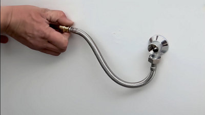 A l’aide de la clé à molette, vissez le flexible de douche sur la rosace et clipsez l’autre embout sur le tuyau en cuivre