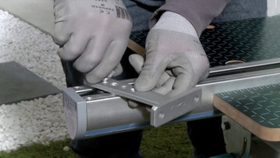 Assemblage d'une patte de fixation en aluminium sur le chariot d’un vérin.
