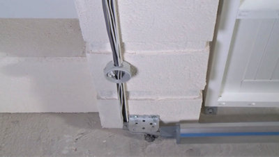 Installation électrique d'un vérin sur une porte de portail.