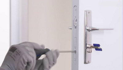 Personne fixant le cylindre avec la vis