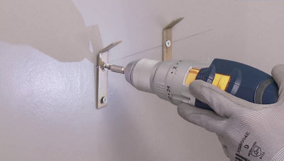 Fixation des pattes au mur avec visseuse