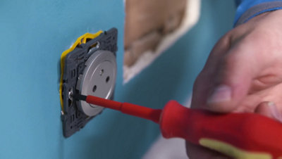 Vissage de la prise dans boite encastrement au mur