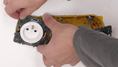 Personne qui insère les mécanismes électriques sur la boite