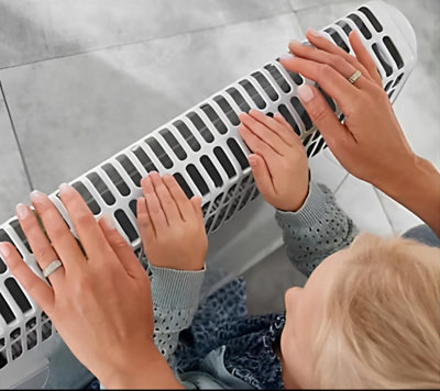 Un enfant et sa mère devant un radiateur d'appoint mobile