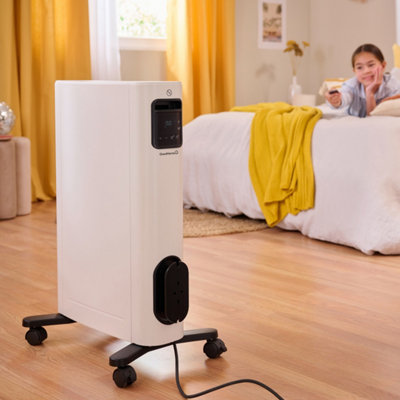 Une filette règle la température de son radiateur d'appoint avec une télécommande