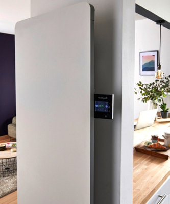 Radiateur électrique connecté GoodHome vertical avec écran digital de contrôle thermique dans un salon