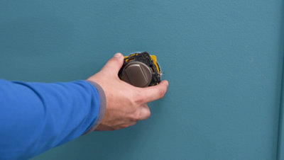 Personne mettant interrupteur dans le mur