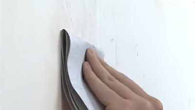 Ponçage du mur enduit avec papier de verre