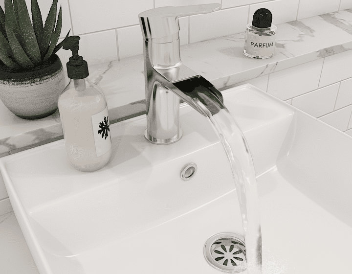 Mitigeur inox design avec de l'eau qui coule dans l'évier blanc
