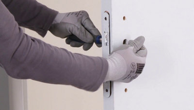 Personne dégageant le boitier de serrure de la porte