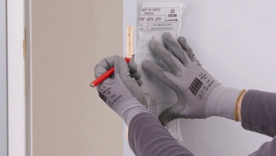 Personne traçant des repères sur la porte au crayon