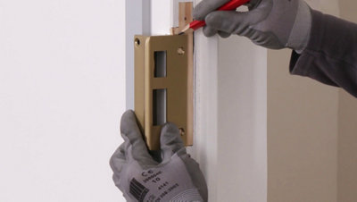 Traçage repère sur le bâti de porte avec la gâche