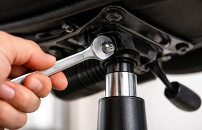 Clé plate pour resserer un boulon sous un fauteuil