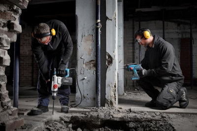 2 hommes sur un chantier utilisant des outils électroportatifs