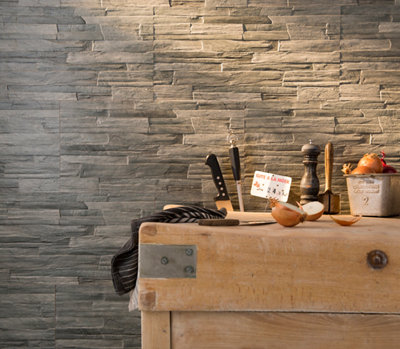 plan de travail en bois, mur en pierre et ustensiles de cuisine contre mur foncé