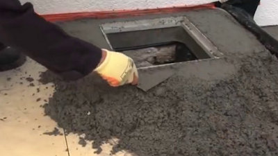Disposez du béton à l’aide de la truelle autour du regard afin d’être précis et lissez. ​