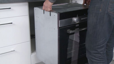Glissez le four sur l’étagère à l’intérieur de son caisson d’encastrement